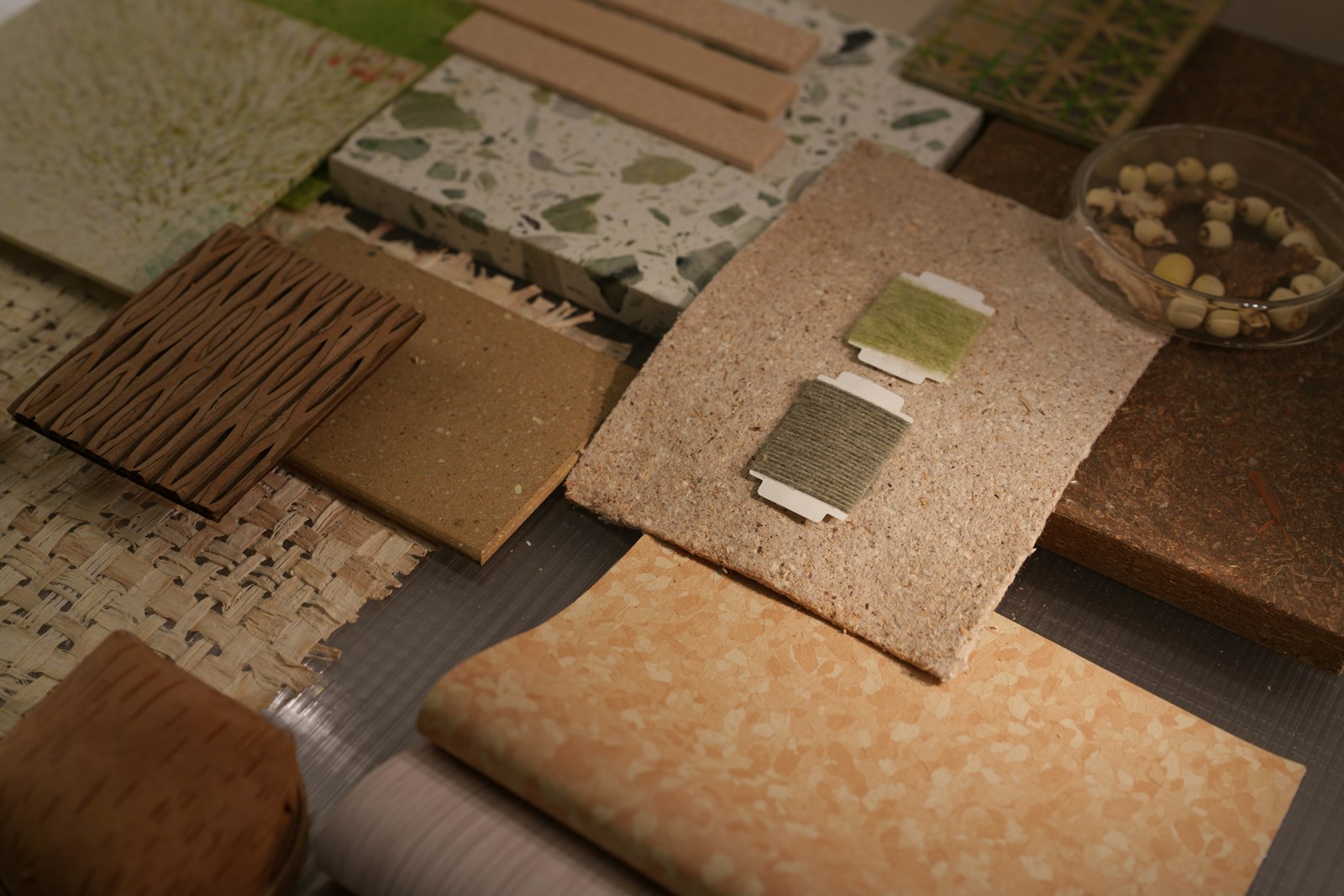 Material samples laid out on a table: terrazzo, cork, timber and woven finishes